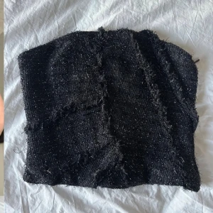 Svart glittrig topp från Zara  - Säljer en svart glittrig topp från Zara  i storlek S. Toppen är croppad och har en rå, fransig struktur med glittriga trådar som ger en cool effekt. Perfekt för dig som gillar att sticka ut med detaljer.