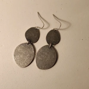 Silvriga ovala hängande örhängen - Snygga hängande örhängen i silverfärgad metall med två ovala plattor på varje örhänge. Använd några gånger, mer ser mer använda än de är. 