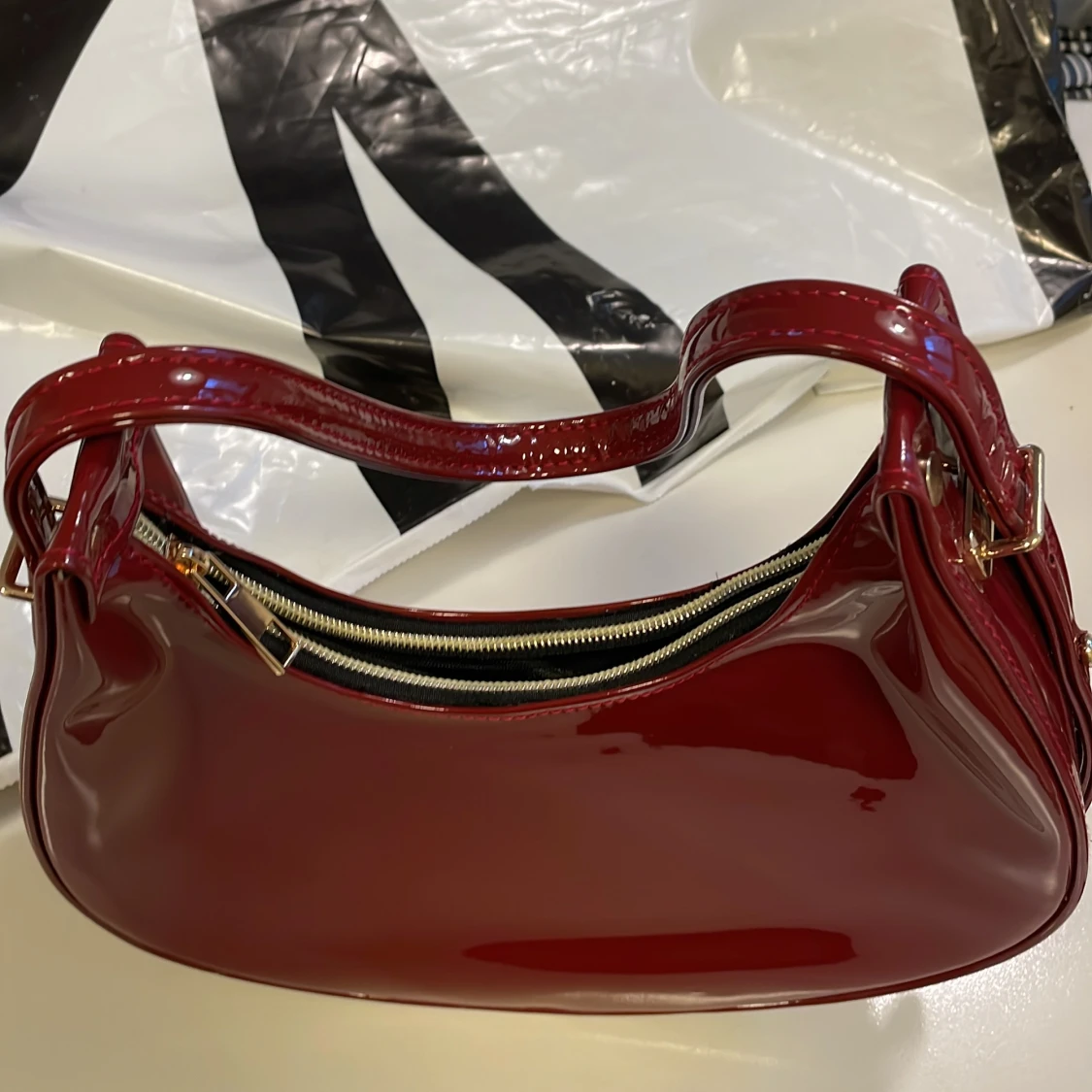 Röd axelväska i blankt syntet