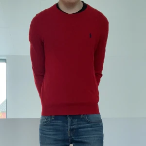Ralph Lauren Stickad Tröja - Säljer en sjukt fet stickad tröja från Ralph Lauren i färgen röd. Tröjan är i bra skick då den har tagits väl hand om och sitter i strl S. Den är i Merino ull och hör gärna av er vid frågor elr funderingar!!