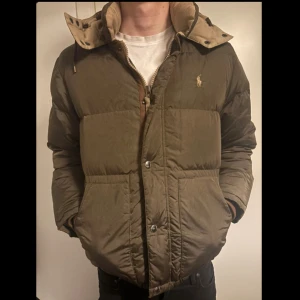 Ralph Lauren dunjacka - Hej! Säljer min sköna, olivgröna dunjacka från Ralph Lauren, eftersom jag har köpt en ny. Den är mycket välskött och varm och kommer passa dig perfekt nu när vintern kommer! Vid en smidig affär är priset självklart förhandlingsbart. Tveka inte att höra av dig om du har frågor! Mvh.