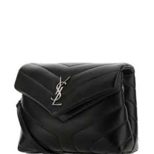 Svart quiltad axelväska från YSL - Snygg svart axelväska från YSL med quiltad design och ikoniskt silvrigt YSL-emblem framtill. Väskan är tillverkad i skinn och har ett stilrent, modernt uttryck med v-format lock och axelrem. Perfekt för dig som vill ha en lyxig och trendig accessoar.(BESTÄLLNINGSVARA TAR 1-3 VECKOR ATT FÅ HEM DIN PRODUKT) man får med box och även dustbag🫰🫰