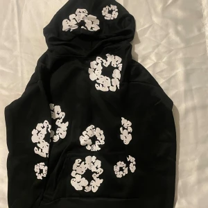 Svarta mjukisbyxor med vit mönster - Svarta mjukisbyxor med unika vita mönster i form av cirklar och kluster över hela byxorna. Byxorna har en avslappnad passform med resår i midjan och vid bensluten. Materialet är mjukt och bekvämt, perfekt för chill dagar. Snygg och modern streetwear-look.