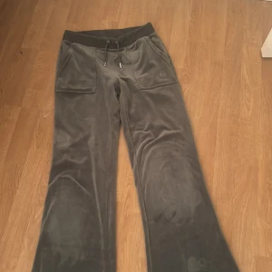 Gröna  Juicy Couture XS - Snygga gröna mjukisbyxor från Juicy Couture i storlek XS. Byxorna har bred resår med snörning i midjan, stora fickor fram och bak med knappar, samt  logga på ena benet. Mjukt och lyxigt material som känns skönt mot huden. Sytt upp dom lite vid benen men går att sprätta upp till normal längd. O dom passar perfekt till mig som är 167. 