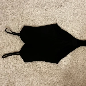 Svart body  - Jättefin svart body i storlek S, perfekt till fest osv🤩köpt den begagnad så vet ej märke men den var ej använd, jag har endast testat den en gång så den är i väldigt bra skick!💞💞💞banden går att ta bort och den har även vadderade kupor!!🤩💞