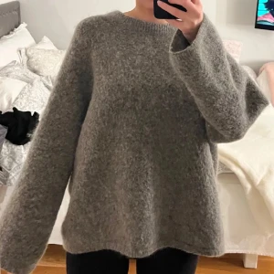 Grå stickad mohair tröja - En mörkgrå stickad tröja ifrån H&M i mohair. Tröjan är oversized och väldigt varm. Väldigt bra kvalitet/skick.