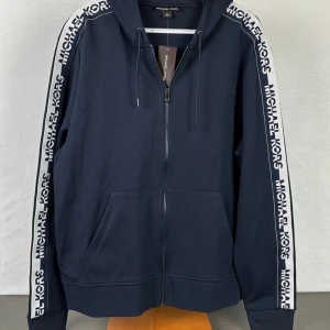  Michael Kors - Snygg marinblå hoodie från Michael Kors med huva och dragkedja framtill.  Köpt för 2500kr