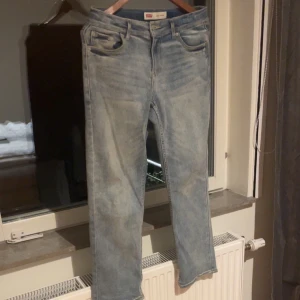 Levi's Loose Taper ljusblå jeans - Ljusblå jeans från Levi's i modellen Loose Taper. Jeansen har en avslappnad passform med avsmalnande ben, klassiska fem fickor och snygga slitningar för en cool look. Tillverkade i mjukt denimtyg med tydliga Levi's-detaljer och etikett bak.