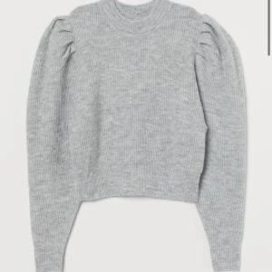 Grå stickad tröja - Stickad tröja med liten volang ärm. Köpt från Hm från divided. Varan är i bra skick och är i storlek xs. Tröjan är någon aning croppad.