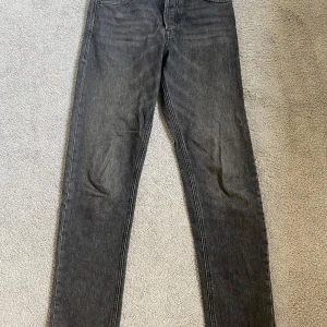 Grå jeans från Jack & Jones - Säljer ett par grå jeans från Jack & Jones i modellen Loose/Chris. De har en loose passform och är perfekta för en avslappnad stil. Jeansen har en klassisk femficksdesign och är tillverkade i slitstarkt denim. Perfekta för både vardag och fest!