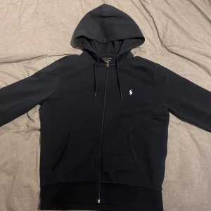 Navy blue polo zip hoodie - Blå polo zip hoodie i fantastiskt skick. Köptes för länge sedan, men har endast använts ett fåtal gånger. Pris kan diskuteras vid snabb affär!
