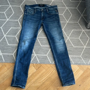Blå jeans från Replay - Säljer ett par snygga blå jeans från Replay, modell Anbass. De har en slim fit passform och är i storlek 30. De sitter tight men långa så tänk på det. L32