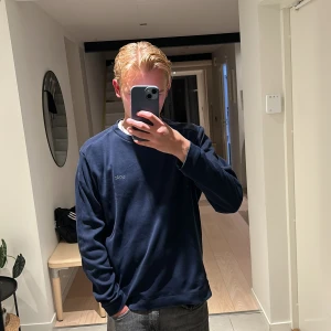 Hugo Boss tröja - Hej jag säljer en mörk blå Hugo Boss sweatshirt som är en lätt o skön tröja o ha på sig, jag väger 59 kilo och är 1,77 lång.