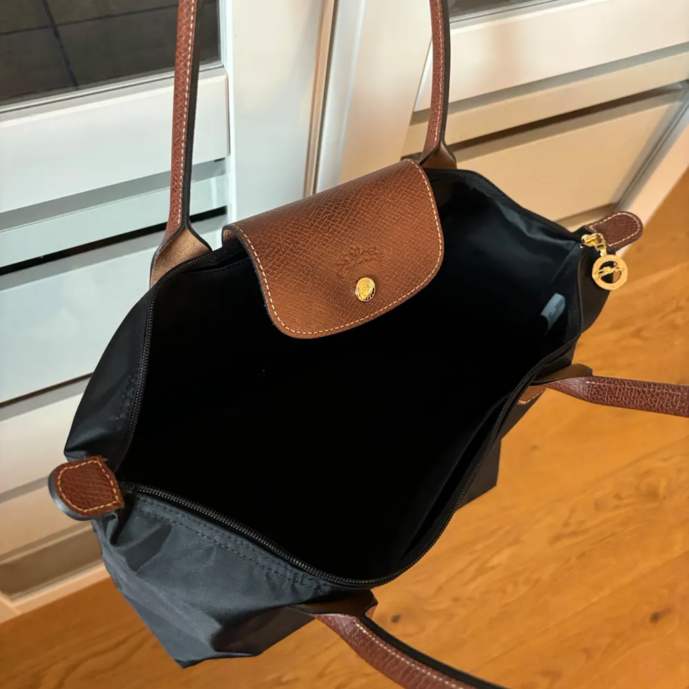 Svart longchamp i strl M. Knappt använd, som ny!!! Köpt på NK för 1499 kr. Säljer för 950 kr. . Väskor.