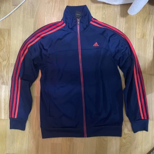 Adidas kofta - Riktigt schysst adidas kofta i färgerna röd och blå. Sällan använts och är i storlek M