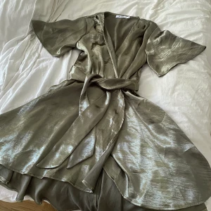 Olivgrön satinklänning  - En superfin klänning från NA-KD i olivgrönt satinliknande tyg. Storlek 36 (S).