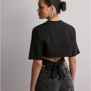 Open Back Tie Tee - Säljer denna jättefina toppen från Nelly. Använd 1 gång. 