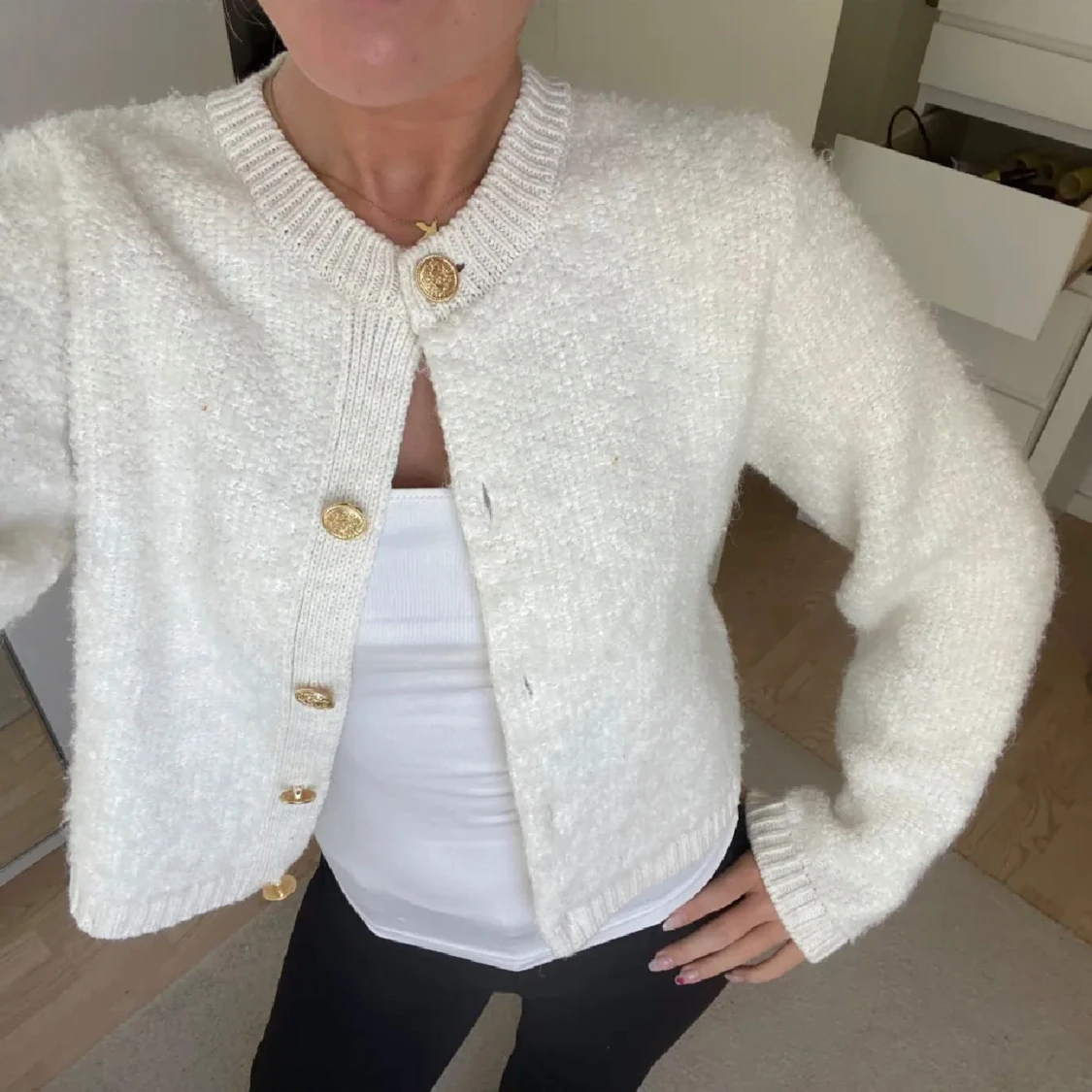 Vit kofta med guldknappar
