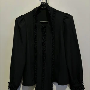 Dear My Love Blus Jirai Kei - Blouse from Dear My Love. The blouse is simple with a tie collar! Perfect for layered coords either with a bustier or a JSK!   Only been used twice, selling as I own a similar top that fit me better!   It’s in DML’s size M, I recommend it for an EU S