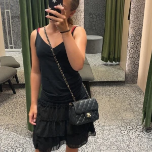 Svart volangkjol - Säljer en superfin svart volangkjol som är perfekt för både vardag och fest. Kjolen har flera lager av volanger som ger en härlig och lekfull look. Den är kort och passar perfekt till sommaren eller en utekväll.