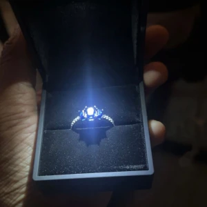 Silverring med blå sten, 925 - Elegant silverring med en stor blå sten i mitten. Ringen har en glittrig design med små stenar längs bandet som ger extra lyster. Perfekt för speciella tillfällen eller som en vacker accessoar till vardags.