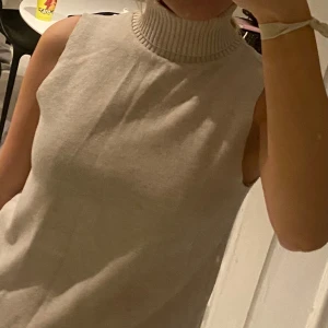 Beige ärmlös polotröja - Säljer en stilren beige ärmlös polotröja Perfekt för lager-på-lager eller som den är. Passar till både vardag och mer uppklädda tillfällen.