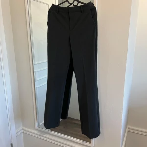 Mörkgråa kostymbyxor - Mörkgråa kostymbyxor med hög midja och raka ben. Storlek 36, använt enstaka gånger