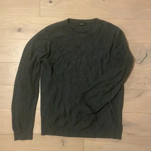 Mörkgrå tröja från J.Lindeberg - Snygg mörkgrå tröja från J.Lindeberg i ett stilrent och klassiskt snitt. Perfekt för kyligare dagar med sin långärmade design. Tröjan har en rund halsringning och är tillverkad i ett mjukt material. Köptes för 1600kr säljer för 200kr. 