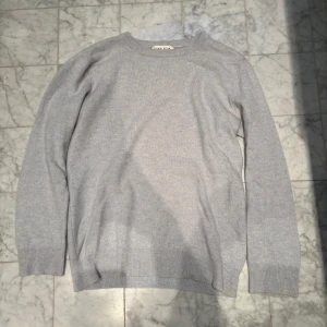 Ljusblå kashmirtröja från Davida - Säljer en stilren och mjuk ljusblå kashmirtröja från Davida. Tröjan har en klassisk design med rund hals och långa ärmar. Perfekt för att hålla sig varm och bekväm under kyligare dagar.