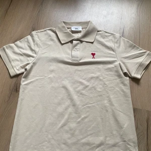 Beige pike - Beige piké ”ami” storlek M. Tröjan är närmare oanvänd och det finns inga tecken på användning. Snabb affär tack men du få såklart ställa frågor. 