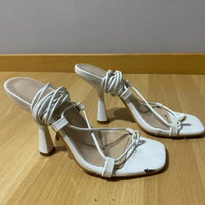 Vita klackskor med snörning - Snygga vita klackskor med elegant snörning och fyrkantig tå. Perfekta för en stilren look.