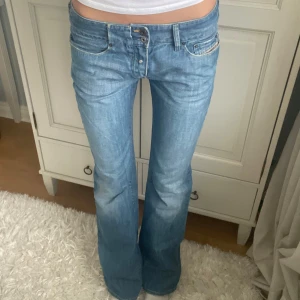 Blå bootcut jeans - Snygga blå bootcut jeans med låg midja från Diesel. Långa i benen och i storlek 30, passar mig som är 180 och brukar bära storlek S☺️Midjemått: 42 , Innerbenslängd: 89, bredd på benslut: 24.