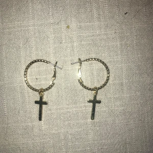 Guldörhängen med korshänge - Snygga guldörhängen med ett korshänge. De har en flätad design på ringen som ger en unik touch. Perfekta för att ge en stilren look.