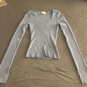 Ljusblå ribbad tröja från H&M - Säljer en ljusblå ribbad tröja från H&M. Tröjan har en figurnära passform med långa ärmar och en rund halsringning. Perfekt för lager-på-lager eller som den är. 💙 använt 2 gånger, säljer för att den inte kommer till användning. Det är ett stretch  material.