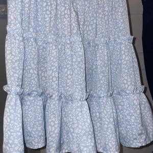 Ljusblå klänning från SHEIN - Charmig ljusblå klänning från SHEIN med ett subtilt leopardmönster. Klänningen har volanger som ger en lekfull touch och är perfekt för varma dagar.