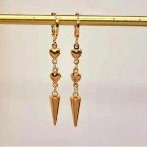 Guldörhängen med hjärtan och spets - Eleganta guldörhängen med tre små hjärtan som leder ner till en spetsig detalj. Perfekta för att ge en romantisk touch till din stil. Lätta att bära och passar till många tillfällen.Handgjorda örhängen●Material-100% rostfritt stål ●Örhängeskrokar -rostfritt stål. Nickel fri. Längd -5cm.  Vattentåliga, ändrar inte färgen! 