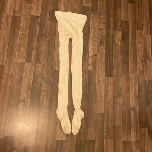 Vita ribbade strumpbyxor - Säljer ett par vita ribbade strumpbyxor i storlek 146-152. De är mjuka och stretchiga, perfekta för att hålla sig varm under kyliga dagar. Materialet är en blandning av bomull och polyester för extra komfort.