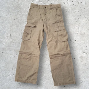 Beige cargobyxor - Säljer ett par beige cargobyxor från Noise! Man kan också  omvandla dem till shorts med dragkedja‼️😋 Storlek: 14/164 fråga bara till om intresserad!! 