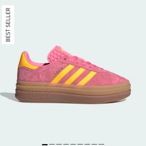 Adidas Gazelle i rosa och gul mocka - Snygga Adidas Gazelle sneakers i rosa mocka med gula detaljer och snörning. Skorna har en klassisk design med en bekväm gummisula och ikoniska tre  ränder på sidan. Köpta i Japan och är använda max 5 gånger. Säljer för att det inte riktigt är min stil.