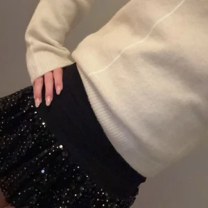 Svart paljettkjol från Zara - Trendig svart kjol från Zara dekorerad med glittriga paljetter. Perfekt för att ge en extra touch till din outfit. Kjolen har en elastisk midja för bekväm passform. Köpte i vintras förra året och andvänd fåtal gånger. Så den är i jätte bra skick 🫶🏼priset kan diskuteras privat och kom privat för frågor❤️