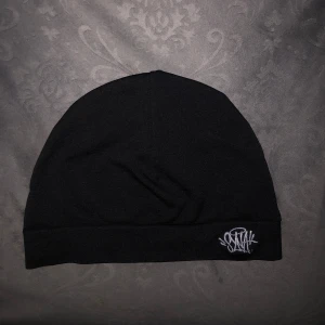 Syna World mössa - Jag säljer mössan då jag inte använder den längre. Mössan är i mycket bra skick och har knappt används. Priset kan diskuteras vid snabb affär.