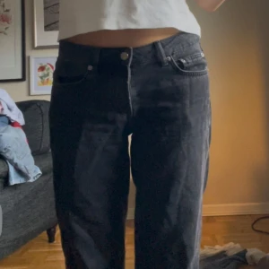 Svarta jeans - Säljer ett par svarta lågmidjade jeans i bra skick. De har en klassisk femficksdesign och en knappgylf. Perfekta för både vardag och fest!