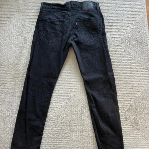 Svarta jeans från Levi's - Säljer ett par svarta jeans från Levi's i bra skick. De har en klassisk femficksdesign och en knappgylf. Perfekta för både vardag och fest! OBS (De ser skrynkliga ut då de är helt nytvättade)  W31 L32