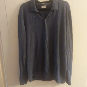 Blå långärmad pikétröja från John Henric - Säljer en stilren blå långärmad pikétröja från John Henric. Perfekt för både vardag och lite mer uppklädda tillfällen. Tröjan har en klassisk krage och knappar framtill. Superbekväm och lätt att matcha med olika outfits!