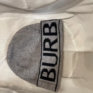 Burberry mössa - Burberry Mössa grå/svart Fint skick, skönt material och aldrig använts utomhus.  DM vid fler funderingar!🙂