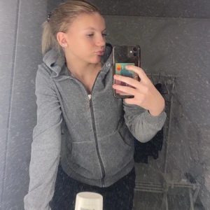 Grå hoodie med dragkedja - Säljer en stilren grå hoodie med dragkedja framtill. Tröjan har långa ärmar och en praktisk huva. Perfekt för en avslappnad look. Spännet på dragkedjan har tappat lite färg. 