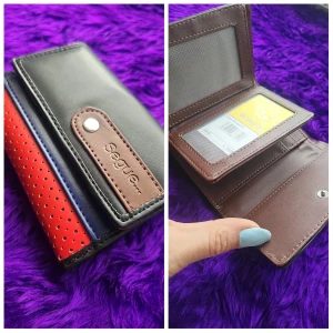 Flerfärgad plånbok från Seeger - Snygg och praktisk plånbok från Seeger i svart, brun, röd och blå. Plånboken har perforerade detaljer och flera fack för kort och ID. Perfekt för att hålla ordning på dina tillhörigheter.