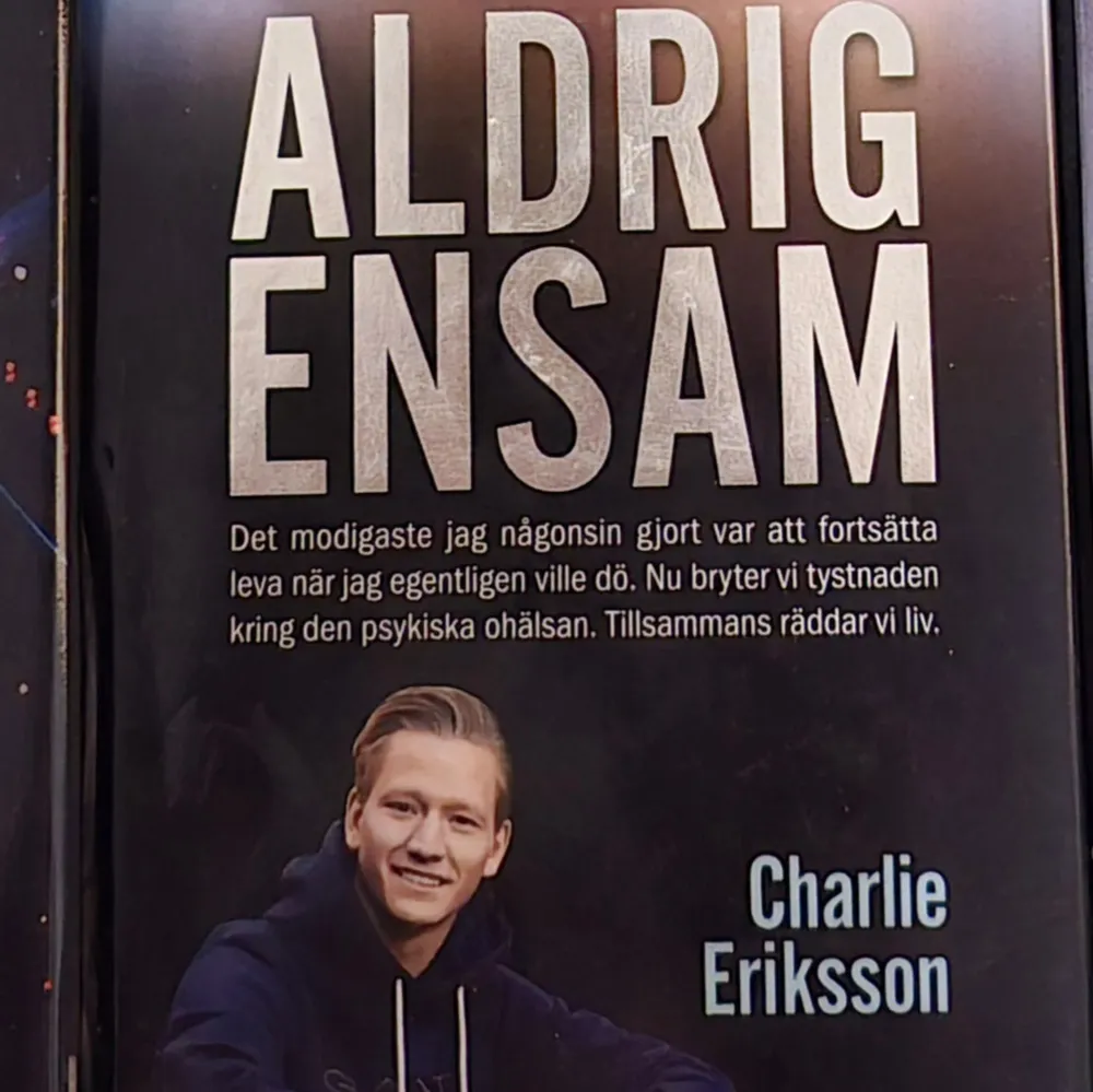 Boken 'Aldrig Ensam' av Charlie Eriksson handlar om att bryta tystnaden kring psykisk ohälsa och modet att fortsätta leva. Författaren delar med sig av sina personliga erfarenheter och betonar vikten av att rädda liv genom att prata om dessa viktiga ämnen.. Böcker.