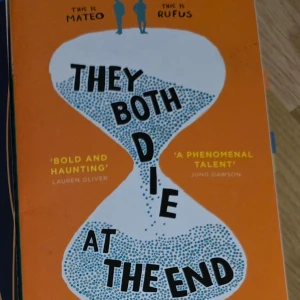 They Both Die at the End - En tankeväckande roman med en orange omslag och en timglasdesign. Boken handlar om Mateo och Rufus och utforskar teman kring liv och död. Citat från Lauren Oliver och Juno Dawson pryder omslaget.