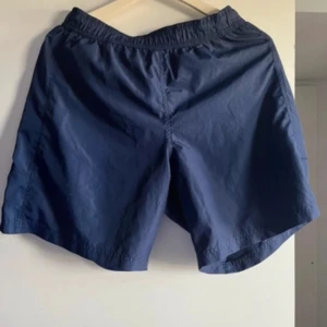 Blå badshorts med resårmidja - Snygga blå shorts med elastisk midja, perfekta för en avslappnad stil. Tillverkade i ett lätt och bekvämt material.